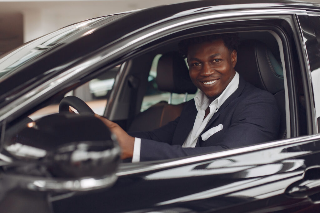 Home handsome and elegant black man in a car salon