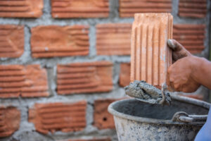 Home masonry worker on the outside wall with a trowel knife.